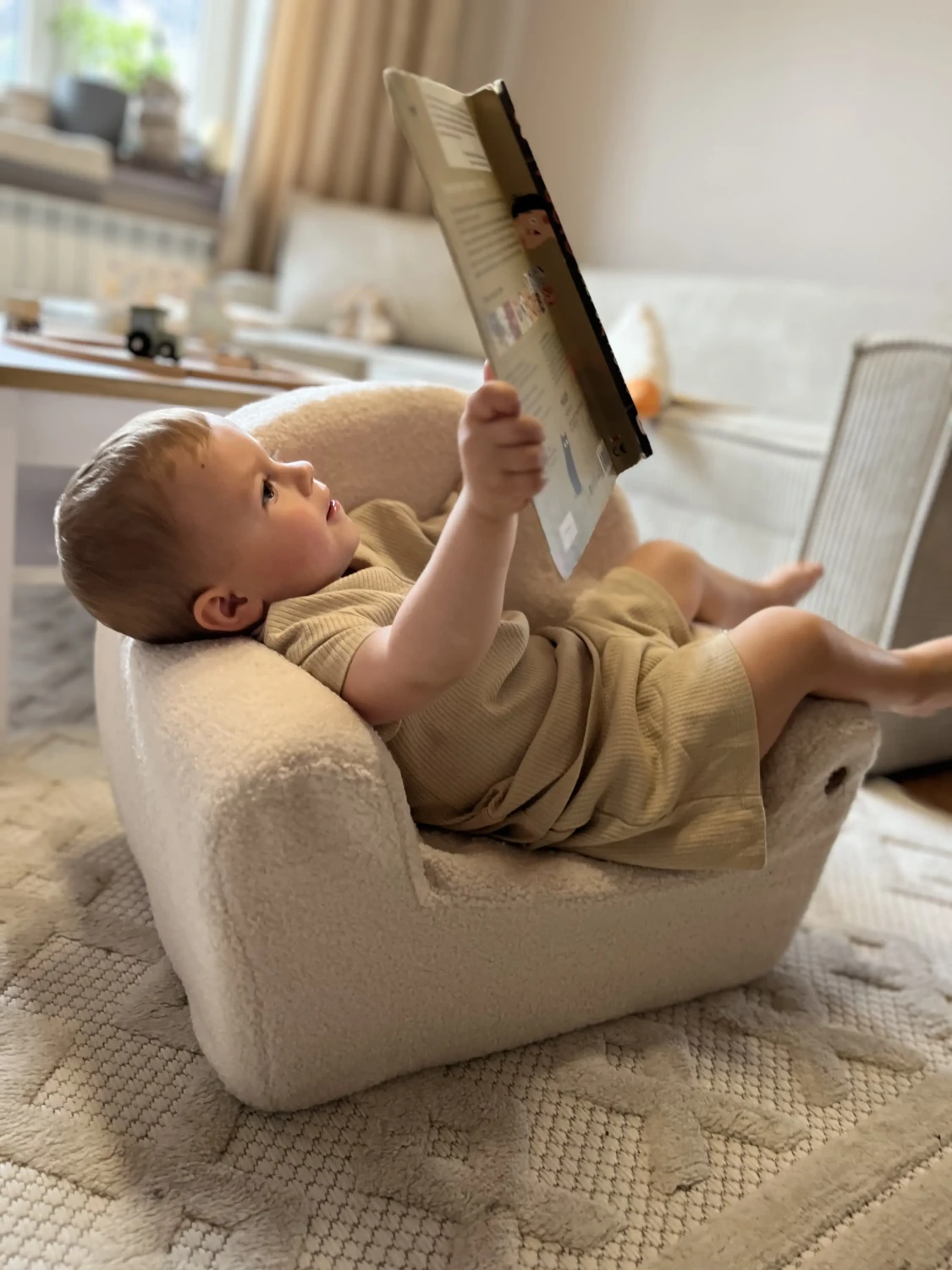 Dziecko czytające książeczkę i siedzące na piankowym foteliku BUBU